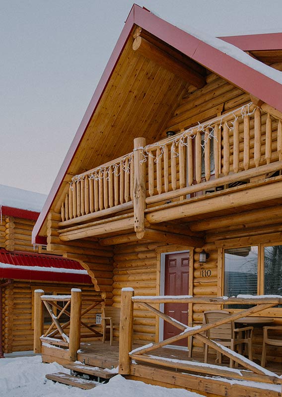 Wooden cabins with red roofs covered in snow.