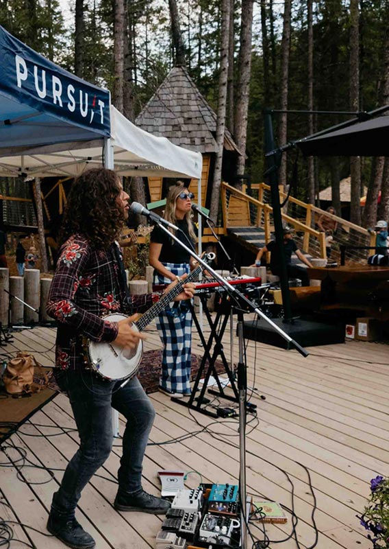 A band performing on an outdoor stage in the summer