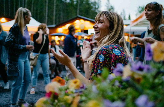 A a person clapping in the crowd at a summer concert at Golden Skybridge.