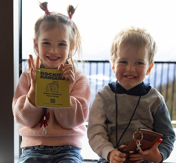 Two children sit together with their Rockies Rangers handbooks.