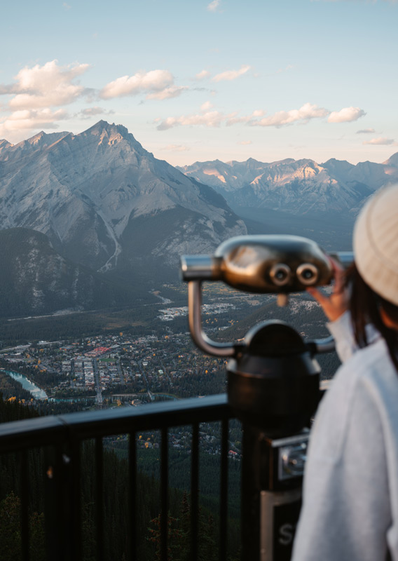 A person looking at the mountain view from the Banff Gondola summit viewpoint.
