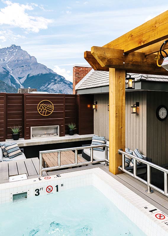 The Mount Royal Hotel rooftop hot tub in the summer, with a view of Cascade Mountain.
