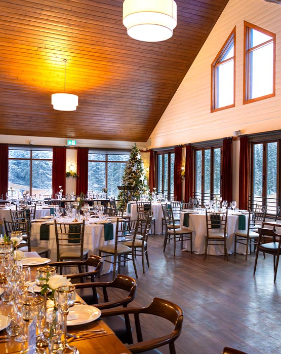 A dining room with tables set up for a wedding.