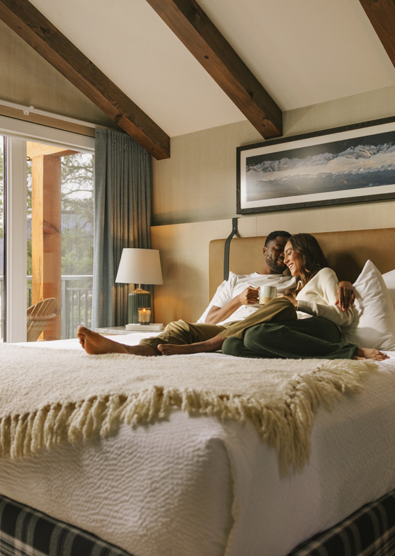 A couple drinking coffee in bed at Pyramid Lake Lodge