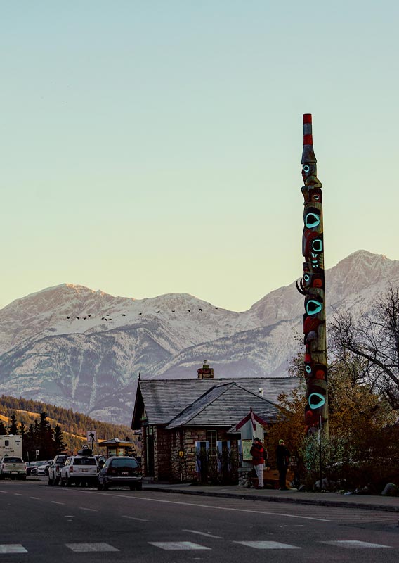 A small town street with mountains in the distance.