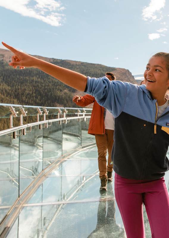 Kids pointing at the view while walking across the Columbia Icefield Skywalk.