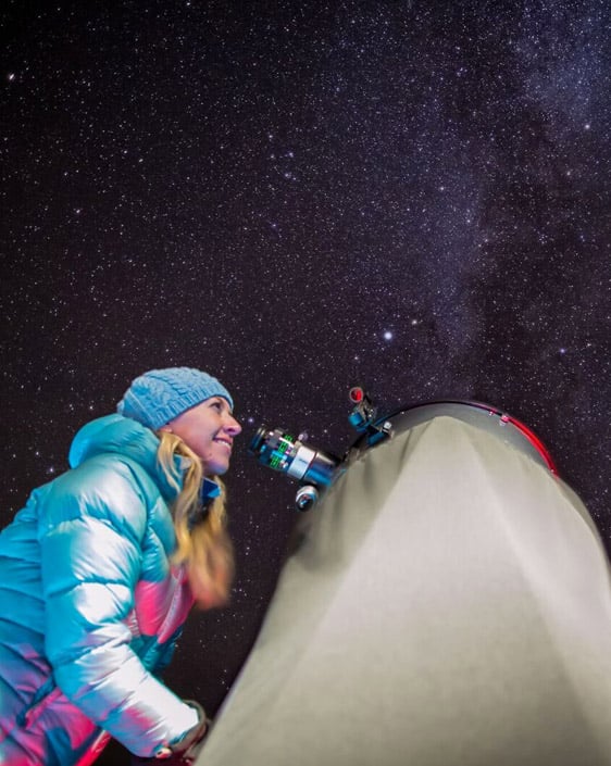 A person looking at the stars through a telescope