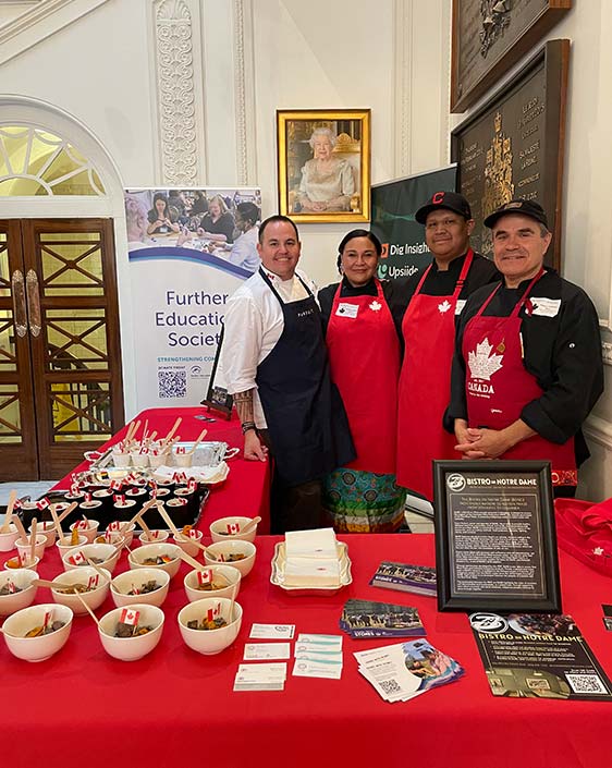 A group pose at at a table at the Further Educational Society event.