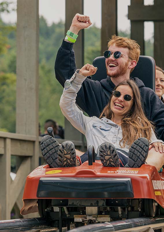 A group of people ride a mountain coaster.