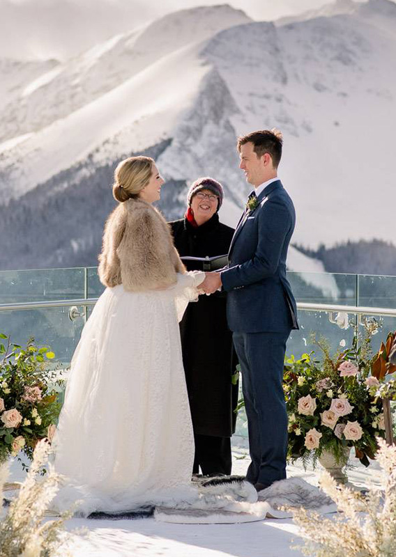 A group table setting set near a tall window overlooking mountain peaks.