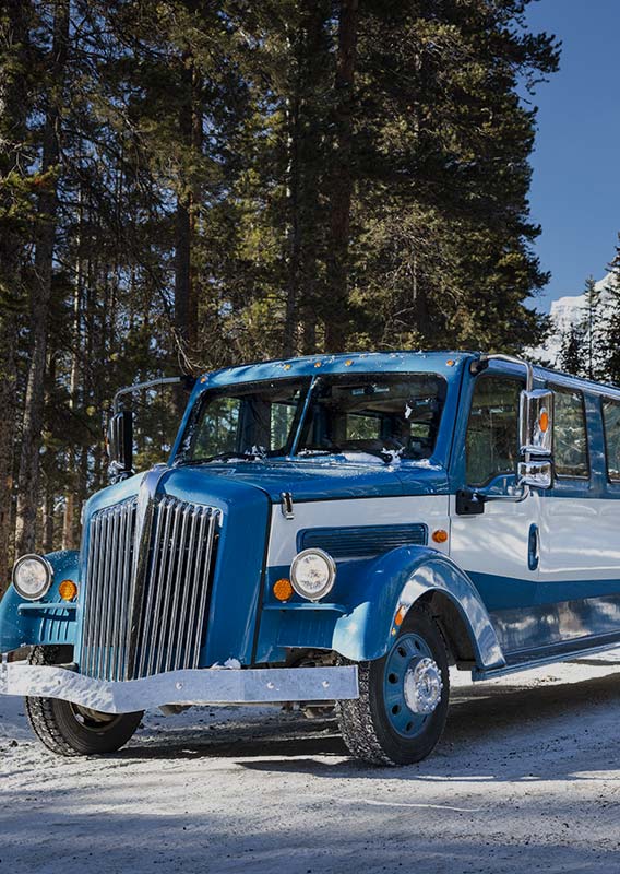 A vintage style touring automobile on a snowy road.