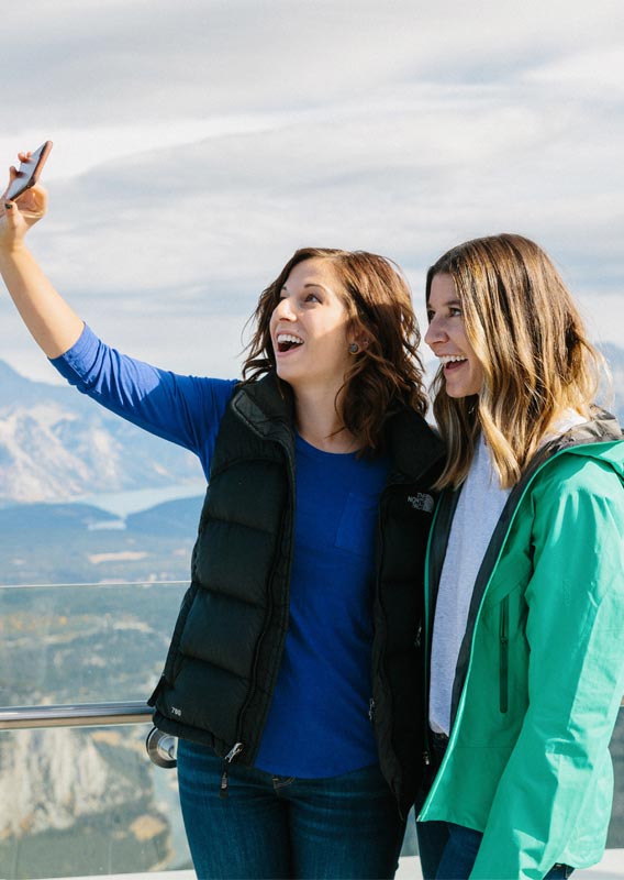 Two friends taking a selfie at the top of Sulphur Mountain