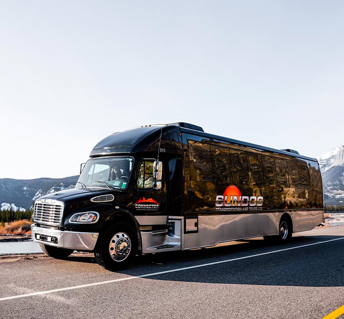 A shuttle bus stopped outside of a hotel.