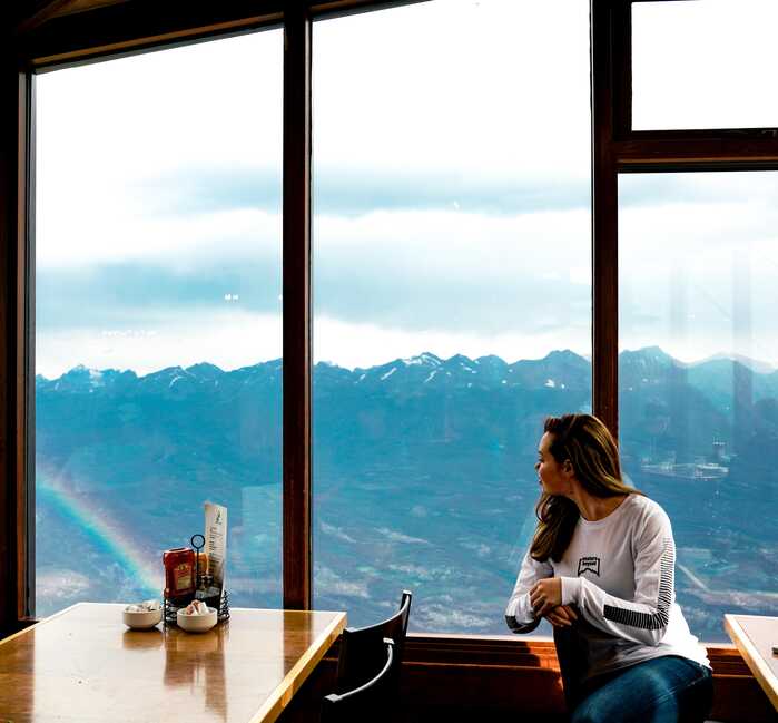 A person looking out the cafe window at the mountain view