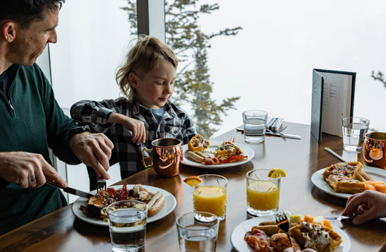 A family seated by a window, enjoying brunch.