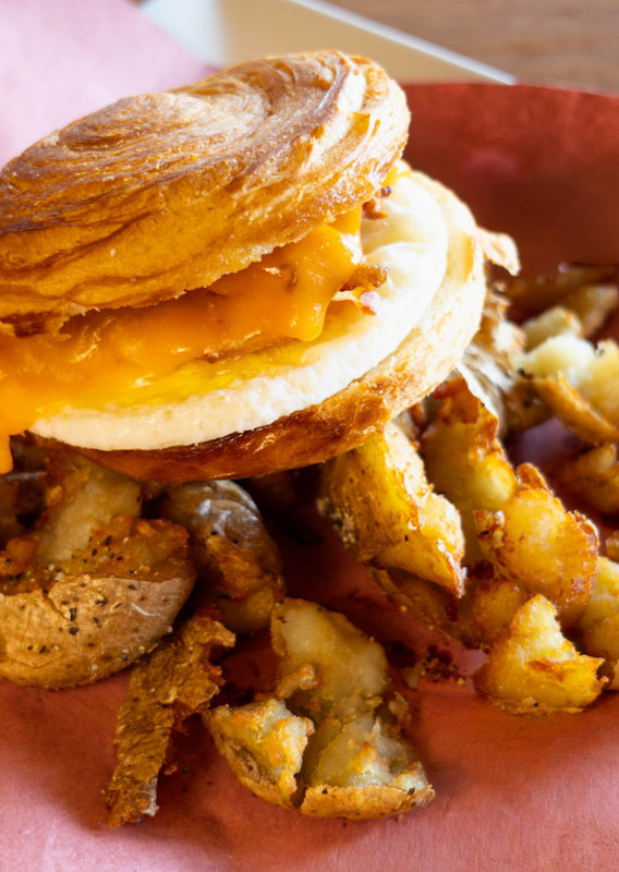 A breakfast sandwich and potatoes to go