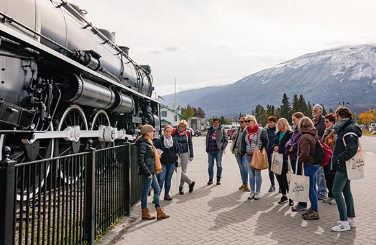 A group of people listen to a guide on a walking tour.